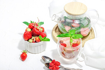 Strawberry tea concept. Good morning concept. Teapot, ripe fruits, healthy beverage