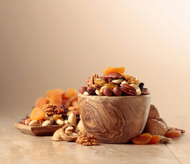 Dried fruits and nuts on a beige ceramic table.