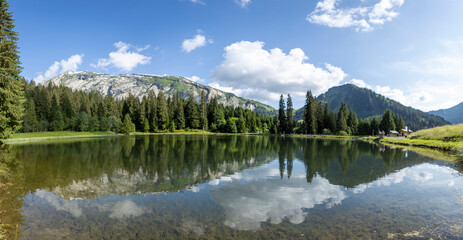 Panorama of Gold miners lake or Lac des Mines d'Or with still water reflecting the spectacular nature of French Alps mountain range during summer. Melt water reservoir. - obrazy, fototapety, plakaty