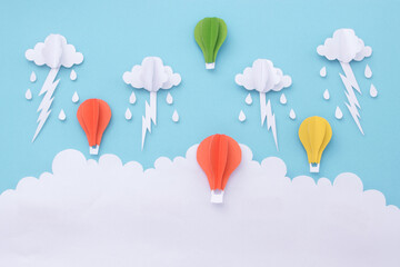 Balloon floating in sky with clouds raindrops and lightning. paper art background.