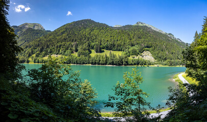 Lac Montriond seen from above. Aerial of French Alps mountain range melt water lake in summer.