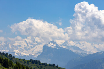 Mont Blanc Massive eternal snow tops in atmospheric haze with dramatic clouds rising above seen...