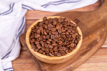 Coffee bean on wood background. Coffee bean in wooden bowl
