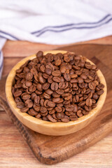 Fototapeta na wymiar Coffee bean on wood background. Coffee bean in wooden bowl. Close up