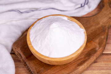 Fototapeta na wymiar Sodium bicarbonate or baking soda on wood background. Sodium bicarbonate powder in wooden bowl