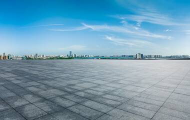 Empty square floor and city skyline with modern buildings under the blue sky