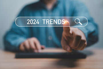Businessman touching to search engine bar with 2024 trends wording for marketing monitor and...