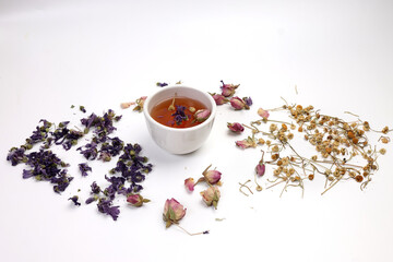 Dry flower tea rose bud butterfly pea chamomile flower transparent ceramic glass tea cup on white...