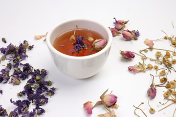 Dry flower tea rose bud butterfly pea chamomile flower transparent ceramic glass tea cup on white background