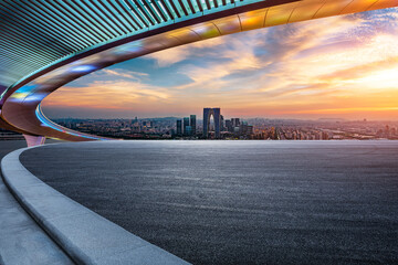 Asphalt road and city skyline with modern building at sunset in Suzhou, Jiangsu Province, China.