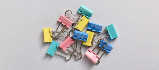 Colorful binder clips on grey background