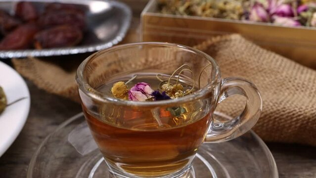 Baklava sweet dessert  date fruit liquid honey natural geomatic hexagon bee wax honeycomb flower tea rose bud butterfly pea chamomile flower tea in transparent glass cup saucer on rustic wood table ba