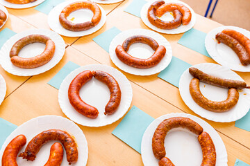 Domestic fresh delicious grilled and fresh handmade sausages on white plate arranged for sausage tournament