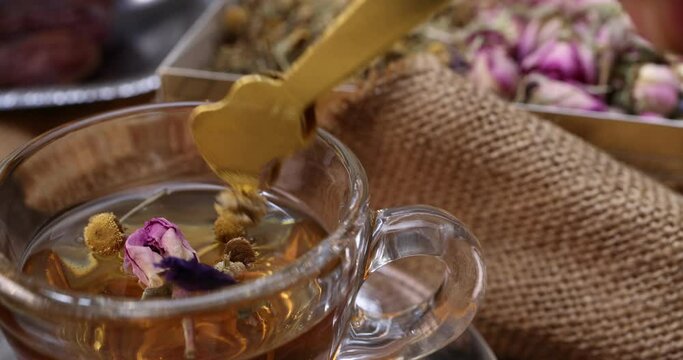 Baklava sweet dessert  date fruit liquid honey natural geomatic hexagon bee wax honeycomb flower tea rose bud butterfly pea chamomile flower tea in transparent glass cup saucer on rustic wood table ba