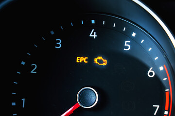 Check Engine symbol on car dashboard in blurred motion effect. Problem with auto motor, service repair concept.