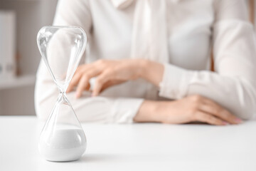 Hourglass on table in office.  Time management concept