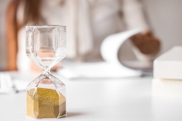 Hourglass on table in office.  Time management concept
