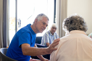 Senior diverse people sitting on chairs and talking in group therapy session