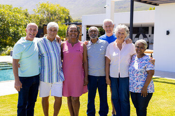 Portrait of happy senior diverse people embracing and smiling in garden