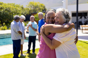 Group of happy senior diverse people embracing and smiling in garden