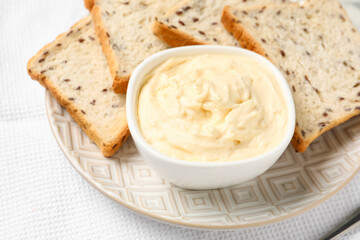 Bowl with tasty cream cheese on table