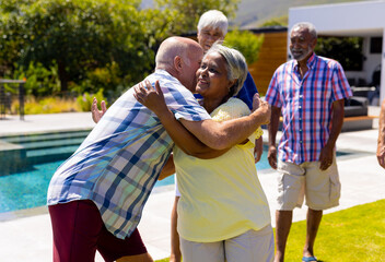 Happy senior diverse people having party and embracing in garden