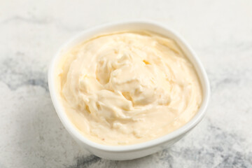 Bowl with tasty cream cheese on white marble background