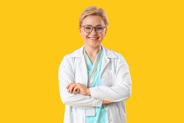 Female medical intern on yellow background