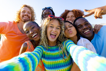 Happy diverse group of friends having party, taking a selfie in garden