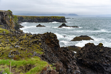 Waves washing against black basalt cliffs at Arnarstapi Cliffs in Snæfellsnes Peninsula, Iceland