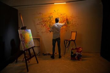 Concept of modern artwork contemporary painting in the art studio artist man painting new picture...