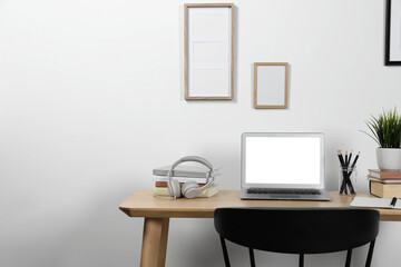Cozy workspace with laptop and stationery on wooden desk at home