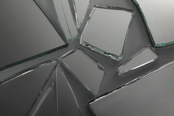 Shards of broken mirror on dark grey background, closeup