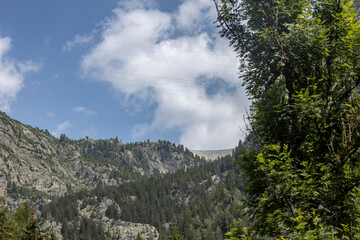 Infrastructure engineering water management dam high up in the French alps mountains seen from below. 