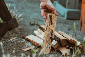 Chopping wood for the fire with an axe. A man's hand with an axe chopping wood, close-up. Preparing for the barbecue