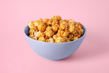 Bowl with tasty popcorn on pink background