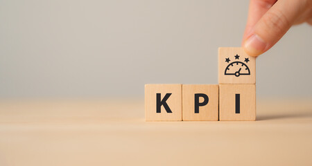 KPI concept. Employee proformance. Key Performance Indicator using business intelligence metrics to measure achievement versus planned target. "KPI" abbreviation and meter  icons on wood blocks.