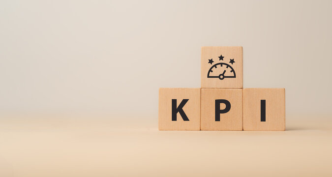 KPI concept. Employee proformance. Key Performance Indicator using business intelligence metrics to measure achievement versus planned target. "KPI" abbreviation and meter  icons on wood blocks.
