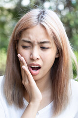 Asian Woman with Toothache, Seeking Dental Pain Relief and Oral Health Care
