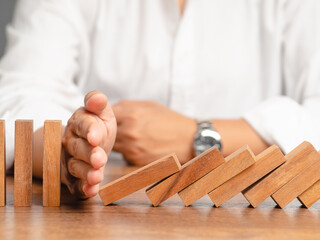 Business professionals stop the crisis domino effect, safeguarding against business collapse. - obrazy, fototapety, plakaty