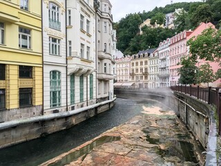 Fototapeta na wymiar Tepla creek channel in Karlovy Vary with hot water from springs making steam at Vridelni street