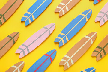 Many different colorful mini surfboards on yellow background