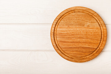 Cutting board on a white table. Pizza board.Kitchen wooden cutting board. Kitchenware. Menu. Recipe. The concept of cooking. Mockup