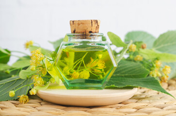 Small vintage bottle with linden (tilia, basswood, lime tree) oil. Natural skin care, homemade spa and beauty treatment.