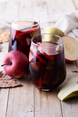 Autumn sangria with pear and apple on wooden table
