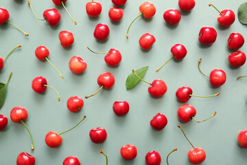 Obraz na płótnie Canvas Many sweet cherries on green background