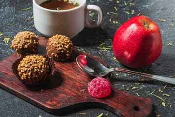 Still life - a cup of herbal tea on the table. Sweet food on a dark background