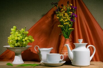 Still life of flowers - summer blooming stems of plants. Draped background - theatrical stage lighting