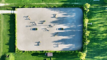 Aerial view of an empty riding arena without horses with a gallop attracted with hedges and crosses...