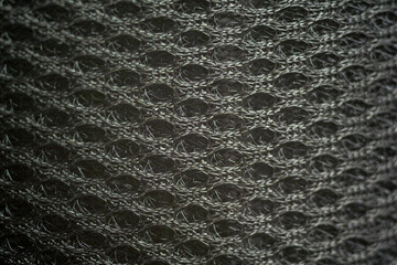 Black synthetic fabric close-up, uniform texture background. Selective focus